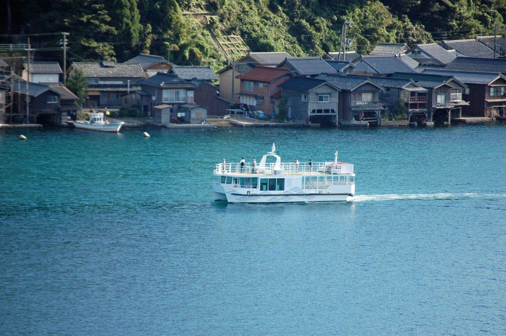 Ine Bay sightseeing boat heading out with seagulls flying close alongside