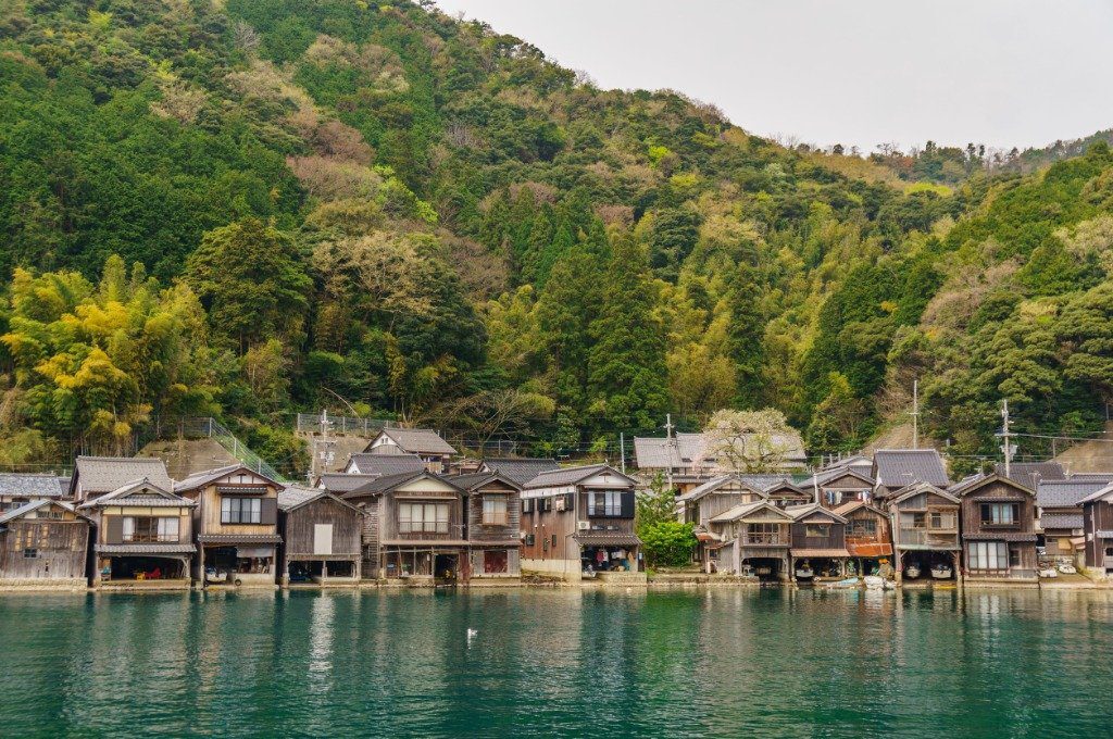 Wooden Ine funaya boathouses lining the clear waters of Ine Bay