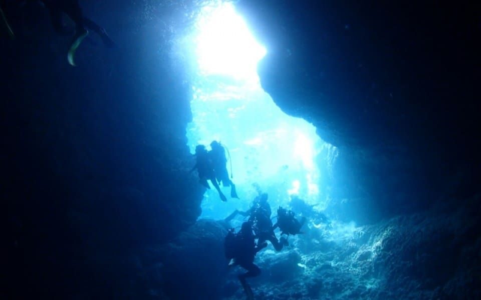 Blue underwater light and a diver inside the Blue Cave, Okinawa