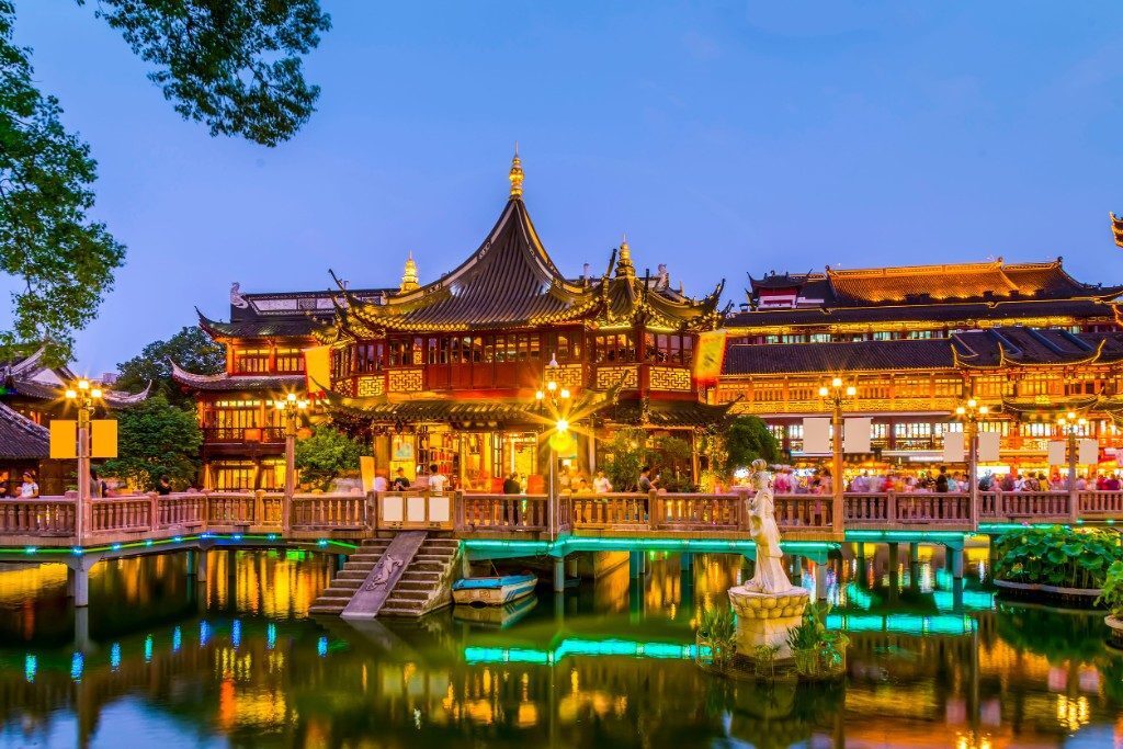 Huxinting Teahouse and the Nine-Bend Bridge at Yu Garden reflected in the water at night