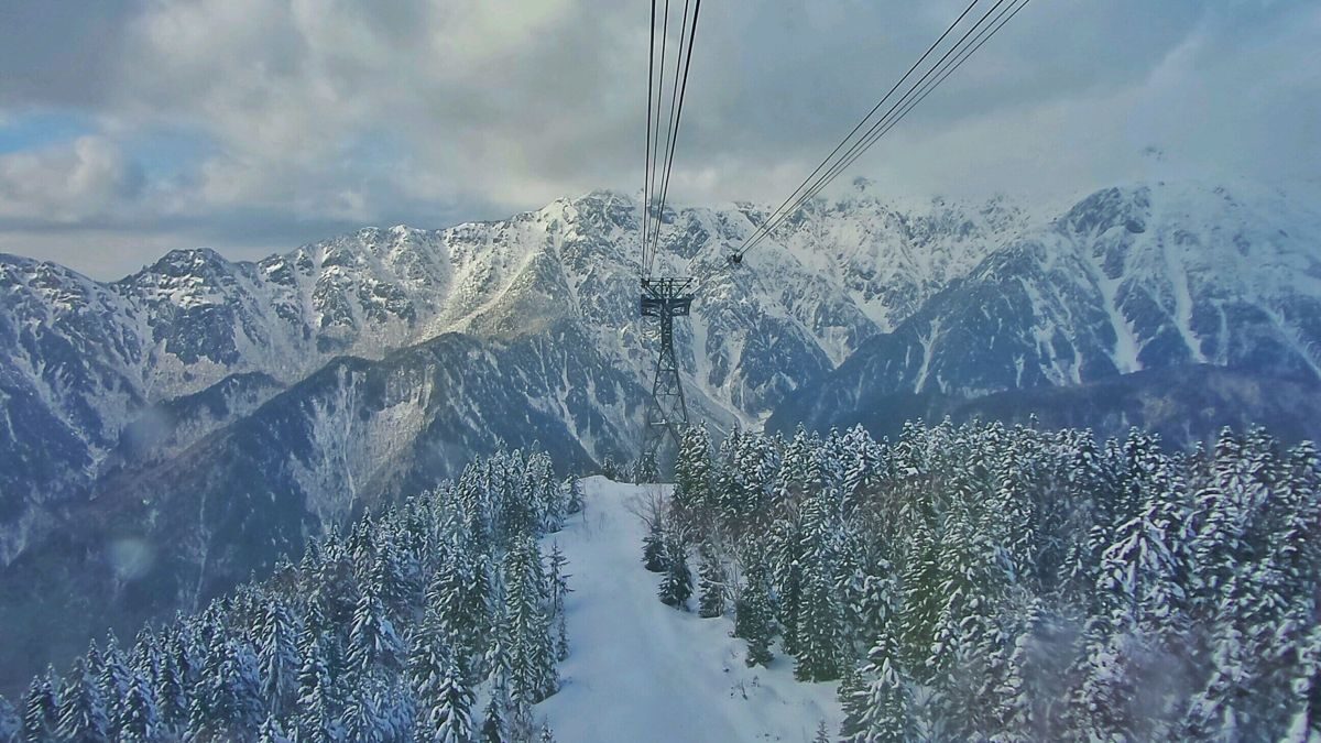 Tateyama Ropeway looking down over snowy forest and the Ushiro-Tateyama mountain range