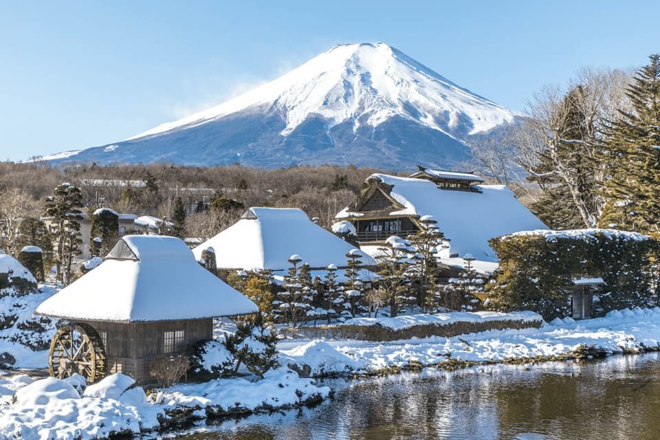 Oshino Hakkai in snow with thatched houses and Mt. Fuji